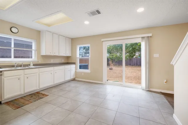 a large white kitchen with a sink and cabinets