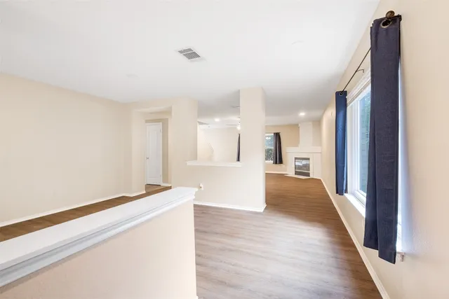 a view of a hallway with wooden floor and staircase
