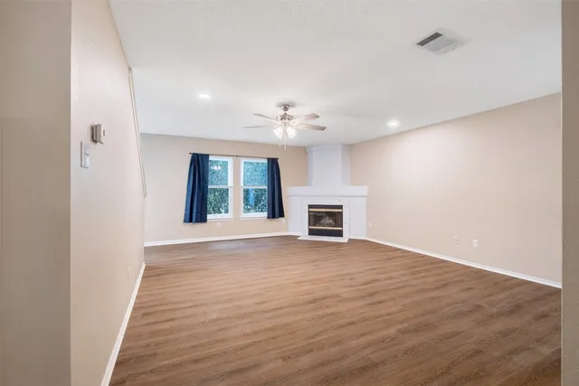 a view of an empty room with a window and fireplace