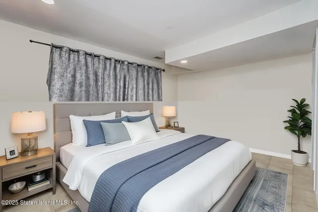 a bedroom with a bed and a potted plant