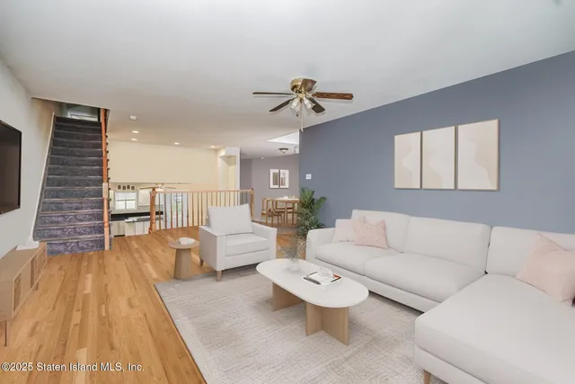 a living room with furniture and a wooden floor