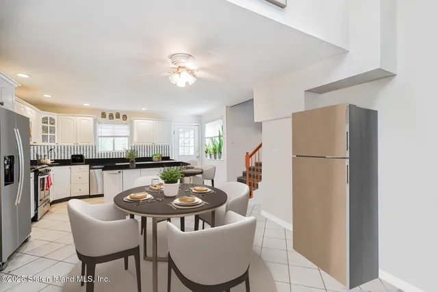 a kitchen with a refrigerator a sink and a dining table