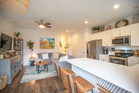 a large kitchen with a table chairs refrigerator and microwave