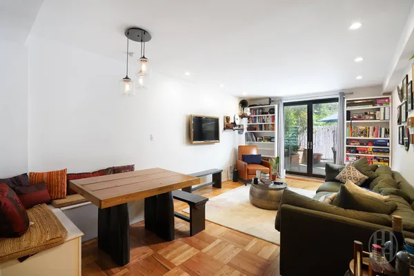 a living room with furniture a flat screen tv and a table