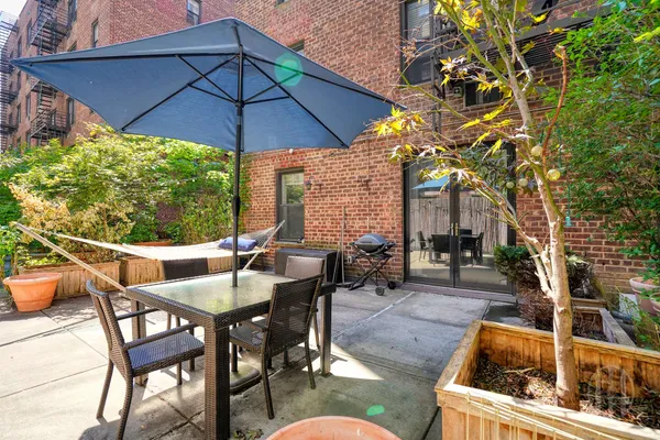 a view of a patio with a table and chairs under an umbrella