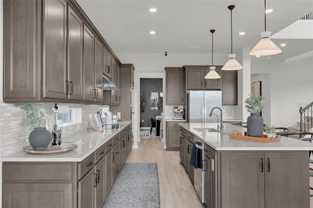 a kitchen with stainless steel appliances granite countertop a sink a stove and a wooden floors