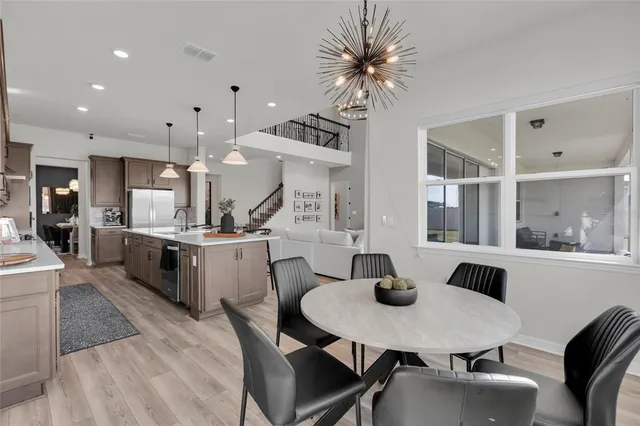 a kitchen with a table chairs a sink dishwasher stove and cabinets with wooden floor