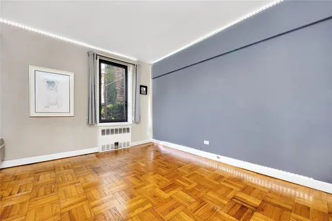 a view of an empty room with window and bathroom