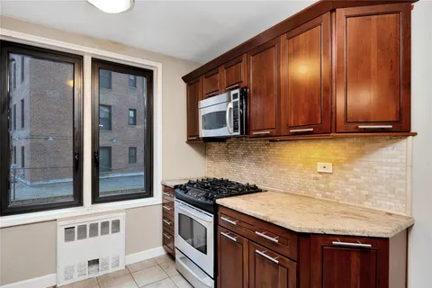 a kitchen with stainless steel appliances granite countertop wooden cabinets and a stove top oven