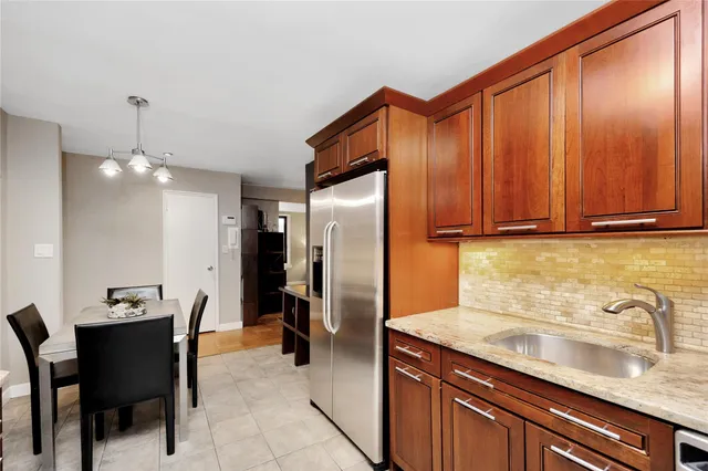 a kitchen with stainless steel appliances granite countertop a refrigerator a sink and a stove