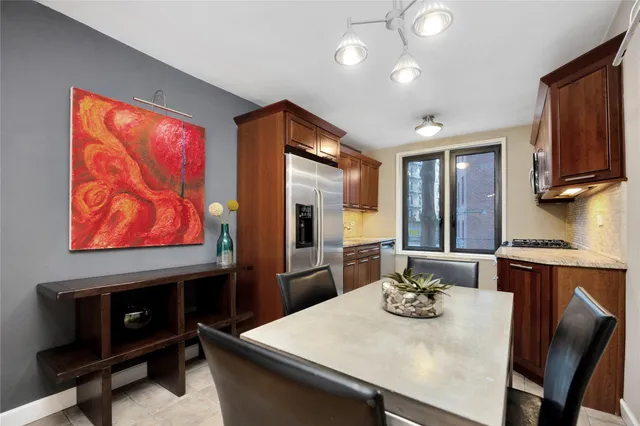 a kitchen with stainless steel appliances wooden floor dining table and chairs