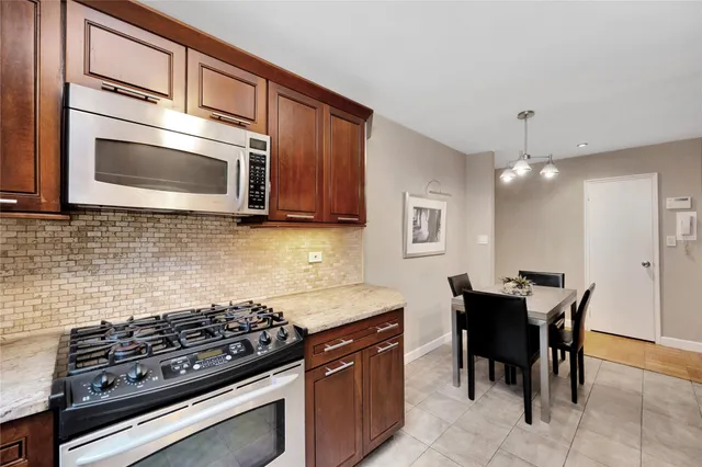 a kitchen with stainless steel appliances granite countertop a stove a sink and a microwave