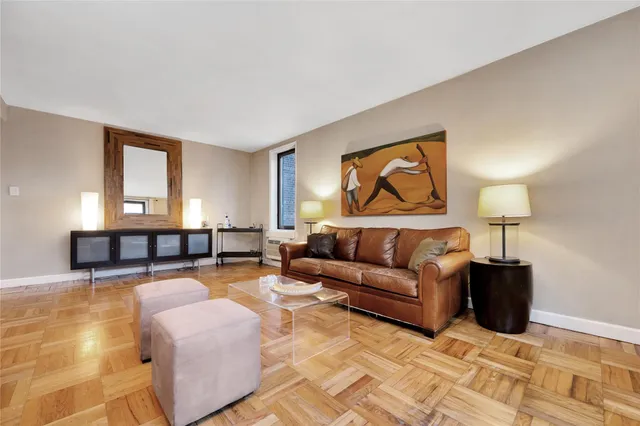 a living room with furniture and a painting on the wall
