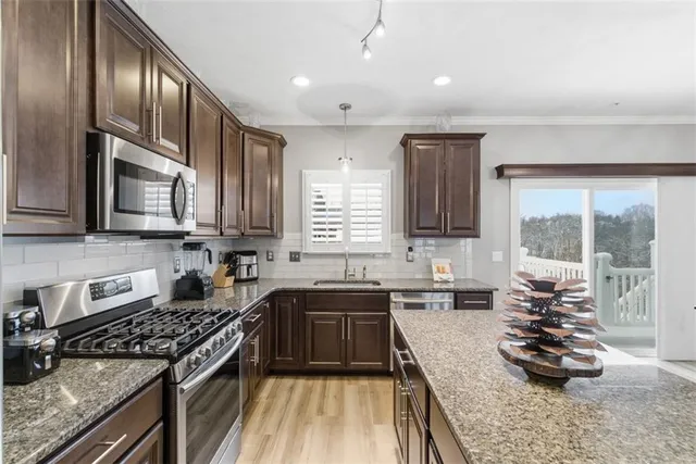 a kitchen with stainless steel appliances granite countertop a stove and a sink