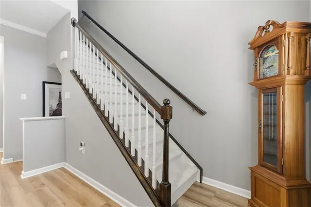 a view of staircase with railing and a chandelier