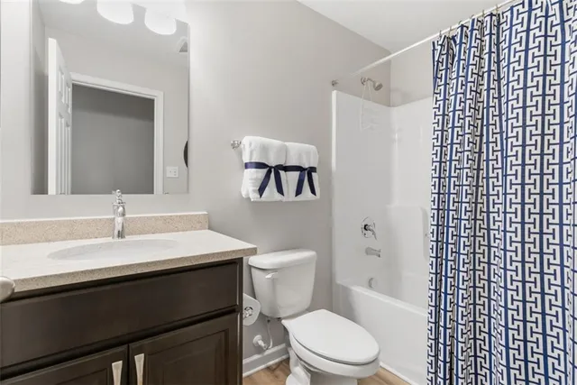 a bathroom with a sink a toilet a mirror and shower