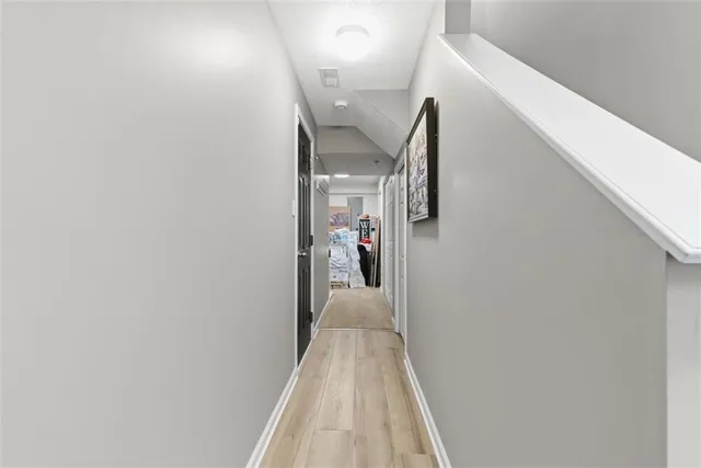 a view of a hallway with wooden floor