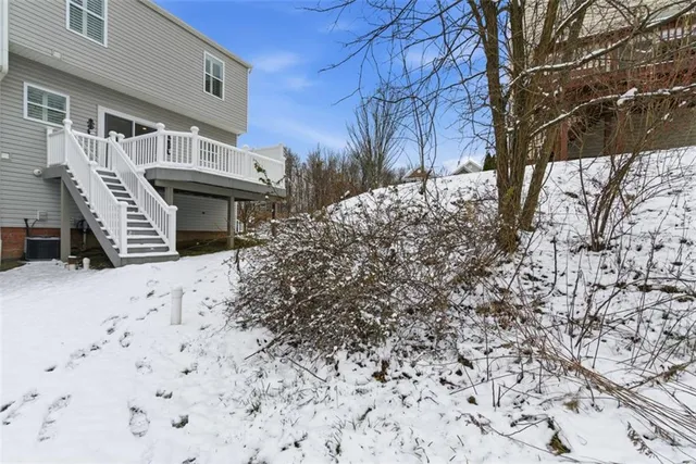 a front view of a house with a yard covered with snow