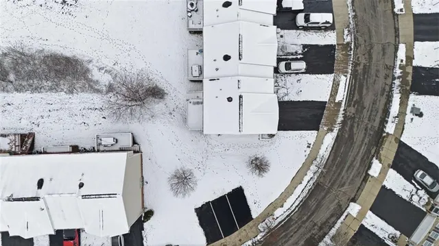 an aerial view of a house with a lake