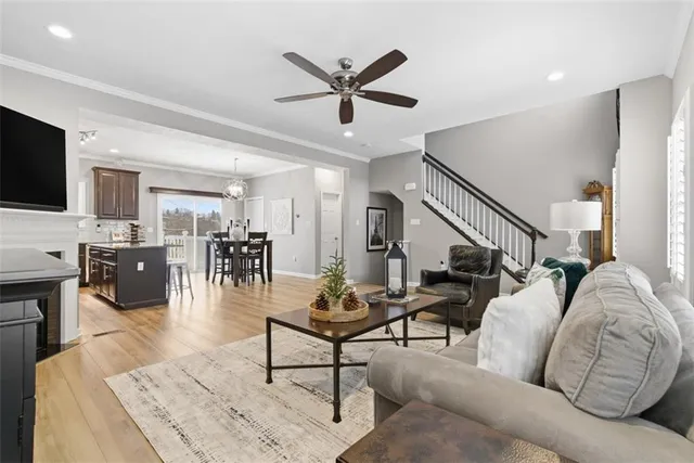 a living room with furniture kitchen view and a window
