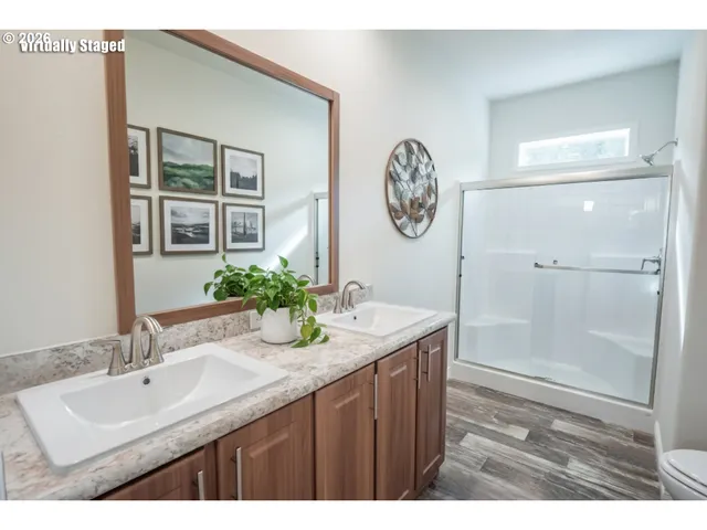 a bathroom with a granite countertop sink a mirror a vanity and shower