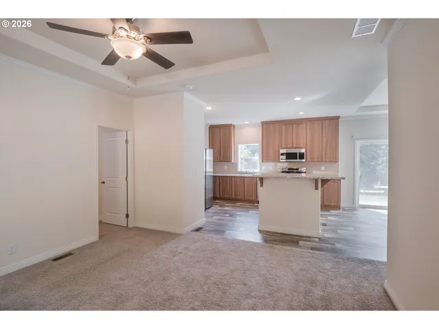 a view of a kitchen with kitchen island a sink stainless steel appliances and cabinets