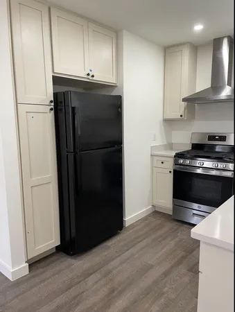 a kitchen with a refrigerator stove and wooden cabinets