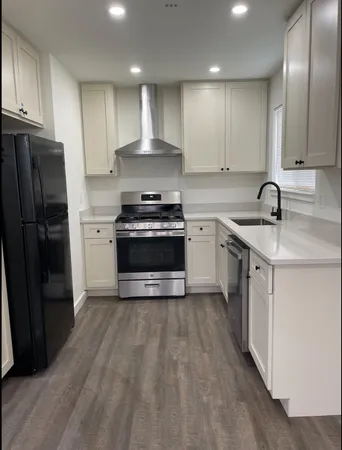 a kitchen with stainless steel appliances granite countertop a sink a stove a refrigerator and cabinets