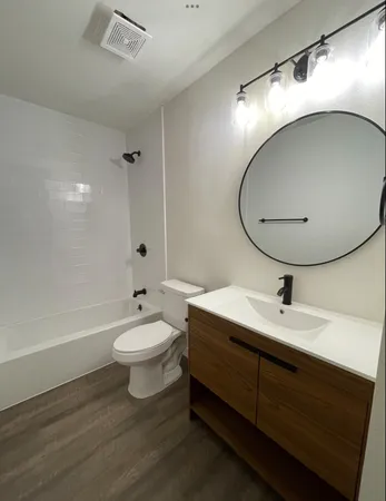 a bathroom with a sink a toilet and a mirror