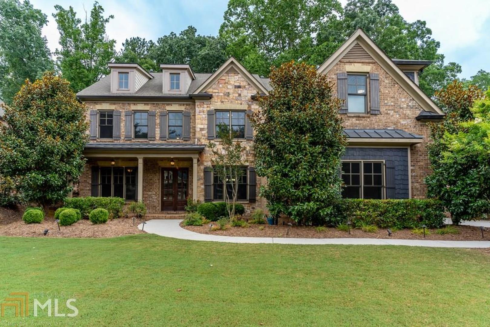 Gorgeous brick and stone Custom home with front porch, 3 car garage, 6 bedrooms and finished terrace level.