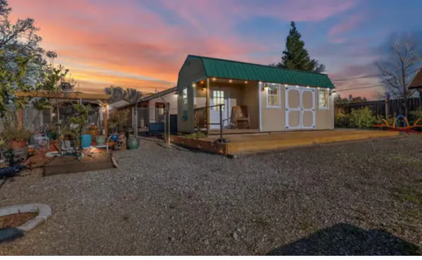 a backyard of a house with barbeque oven and outdoor seating