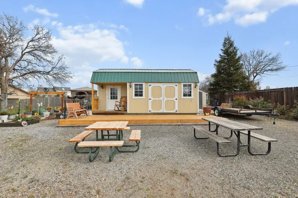 a view of a white house with a yard and sitting area