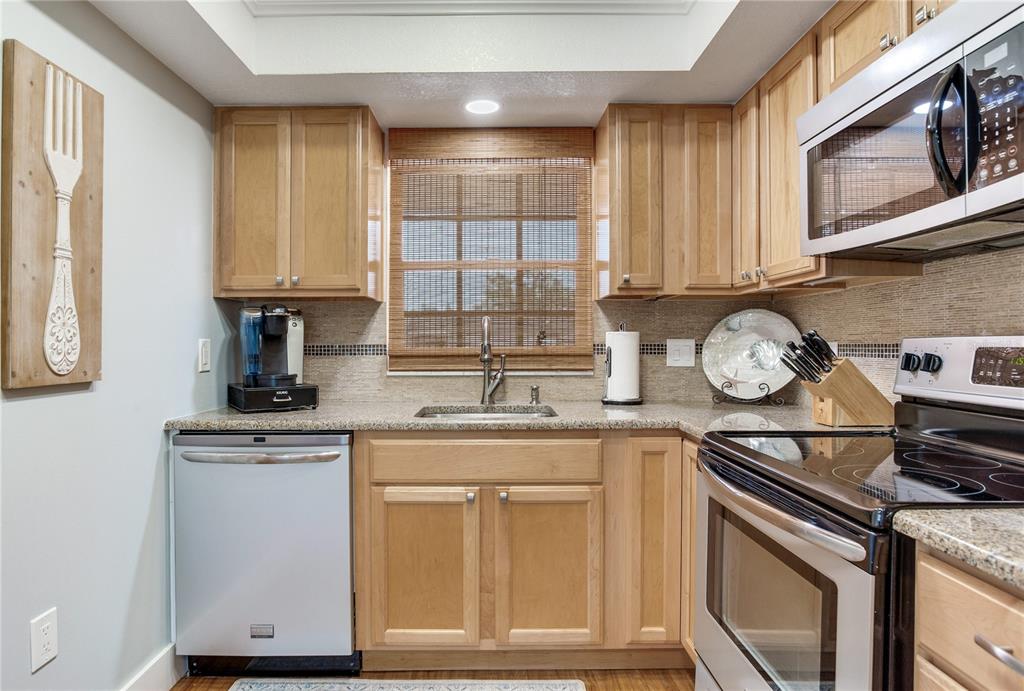 12900 Vonn Road, Unit A204 Largo, FL 33774 - Photo 22 of 40 a kitchen with stainless steel appliances granite countertop a sink a stove cabinets and a window