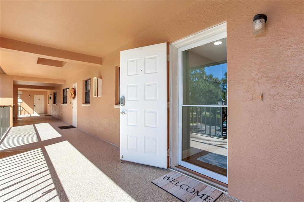 12900 Vonn Road, Unit A204 Largo, FL 33774 - Photo 4 of 40 a view of a hallway with wooden floor and a living room