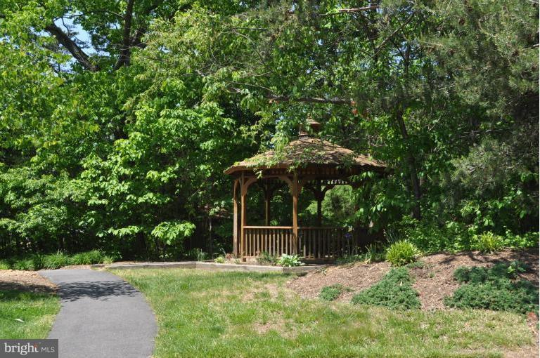 1550 Deer Point Way Reston, VA 20194 - Photo 8 of 30 a backyard of a house with table and chairs under an umbrella