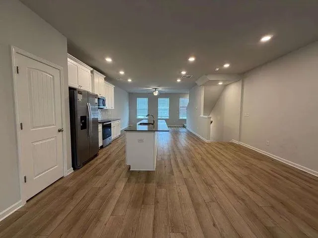 a view of kitchen with stainless steel appliances granite countertop a stove a sink and a refrigerator