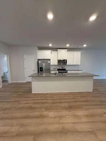 a kitchen with kitchen island sink stove and refrigerator