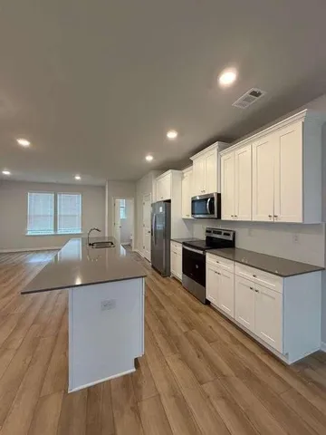 a kitchen with stainless steel appliances white cabinets and refrigerator