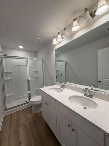 a bathroom with a double vanity sink and mirror with shower
