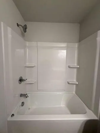 a view of a room with wooden floor and bathroom space