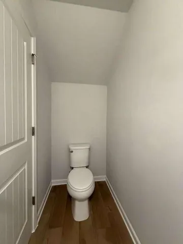 a white toilet sitting next to a shower