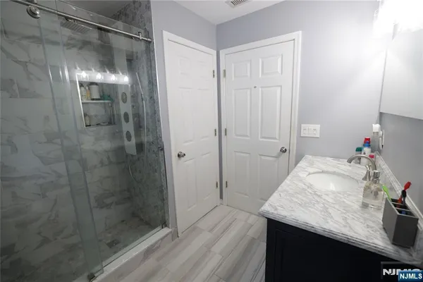 a bathroom with a granite countertop sink a shower and a mirror