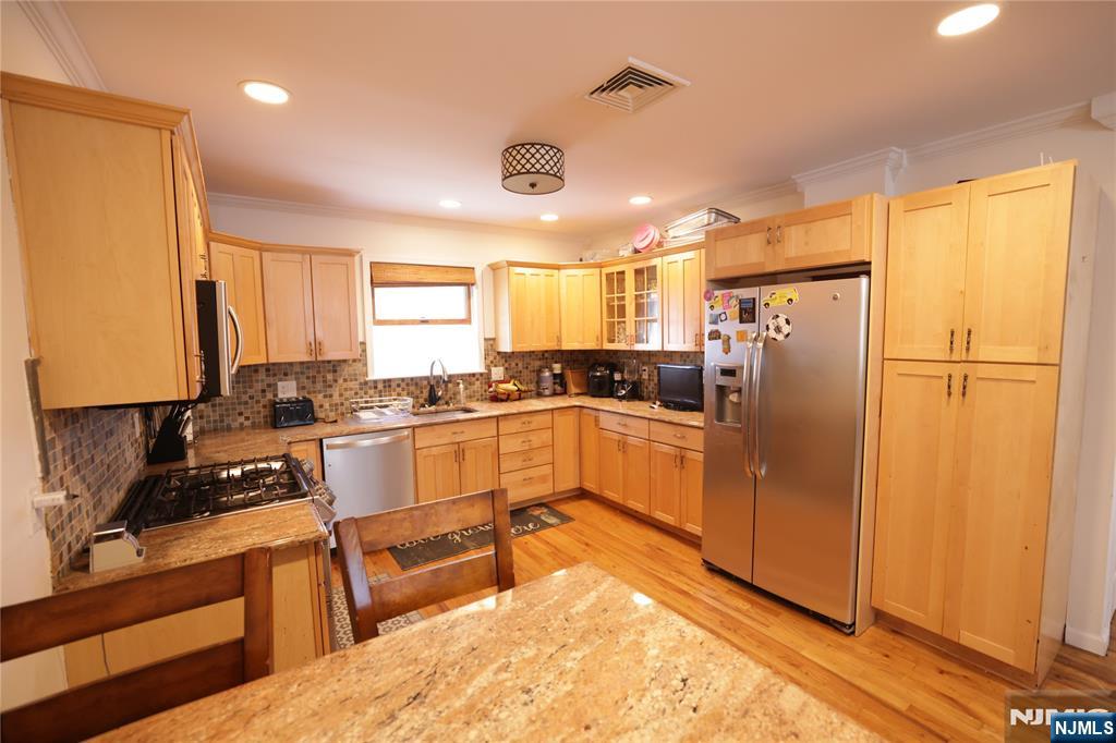 59 Spring Valley Avenue Hackensack, NJ 07601 - Photo 7 of 26 a kitchen with a refrigerator a sink and cabinets
