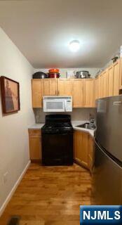 59 Spring Valley Avenue Hackensack, NJ 07601 - Photo 10 of 26 a kitchen with a sink and a refrigerator