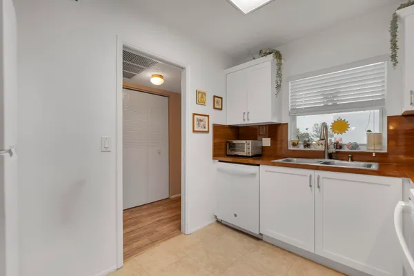 a kitchen with granite countertop white cabinets and white appliances
