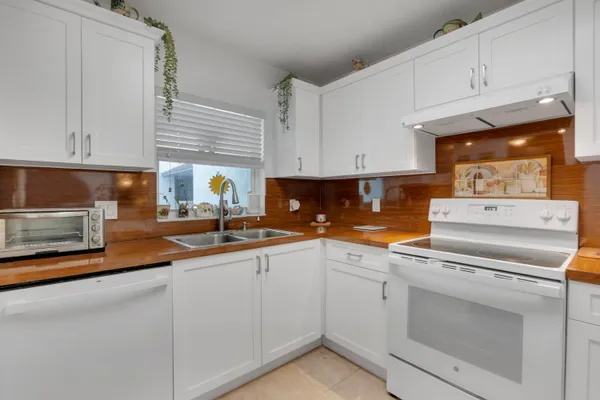 a kitchen with granite countertop white cabinets and white appliances