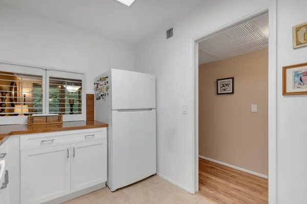 a kitchen with white cabinets and refrigerator