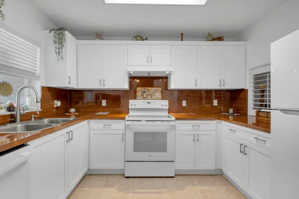 a kitchen with white cabinets and white appliances