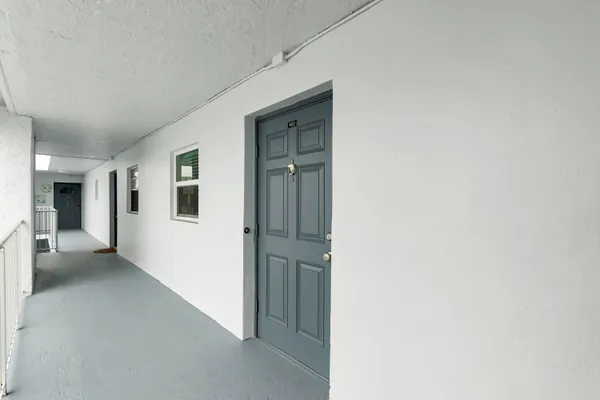 a tall yellow building with trees in front of it