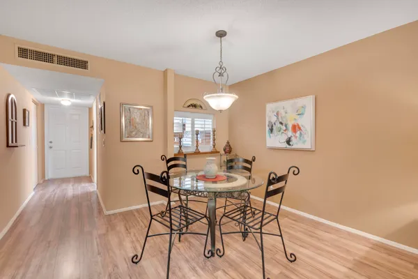 a dining room with furniture a chandelier and wooden floor